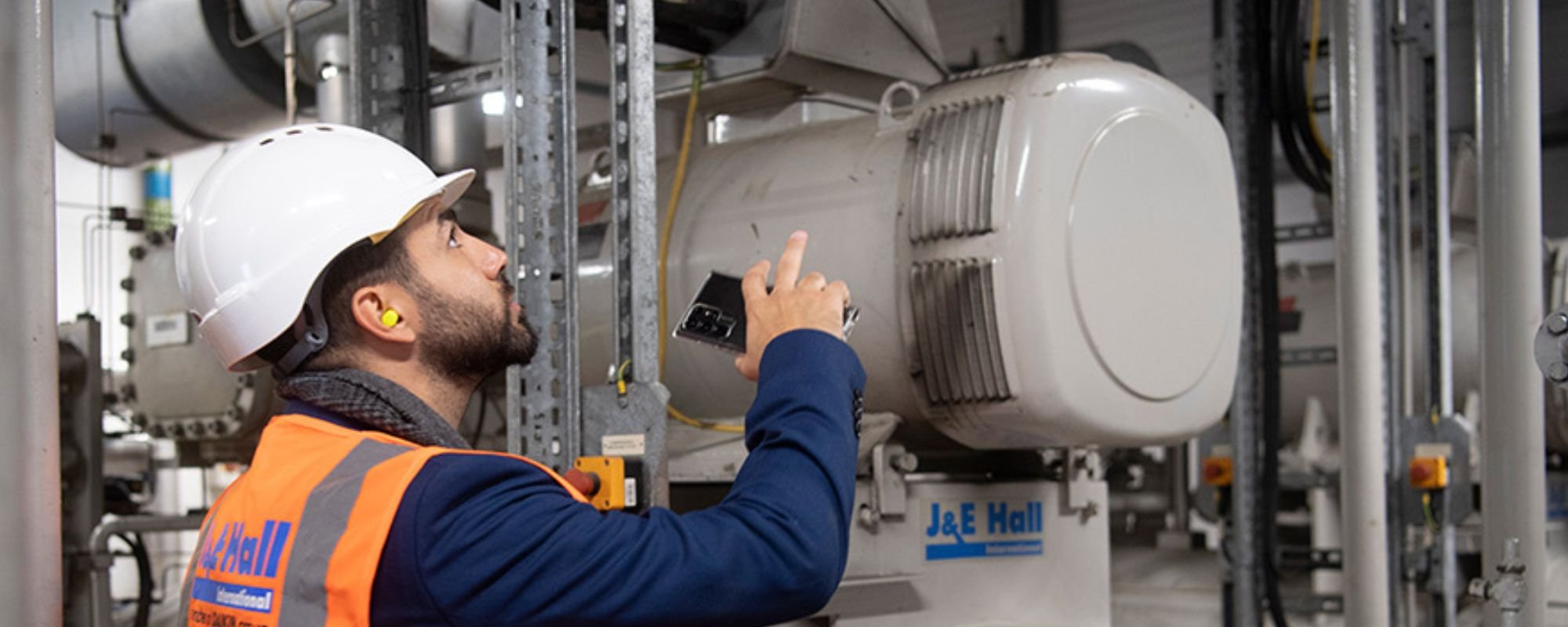 Worker with a hardhat on looking at equipment