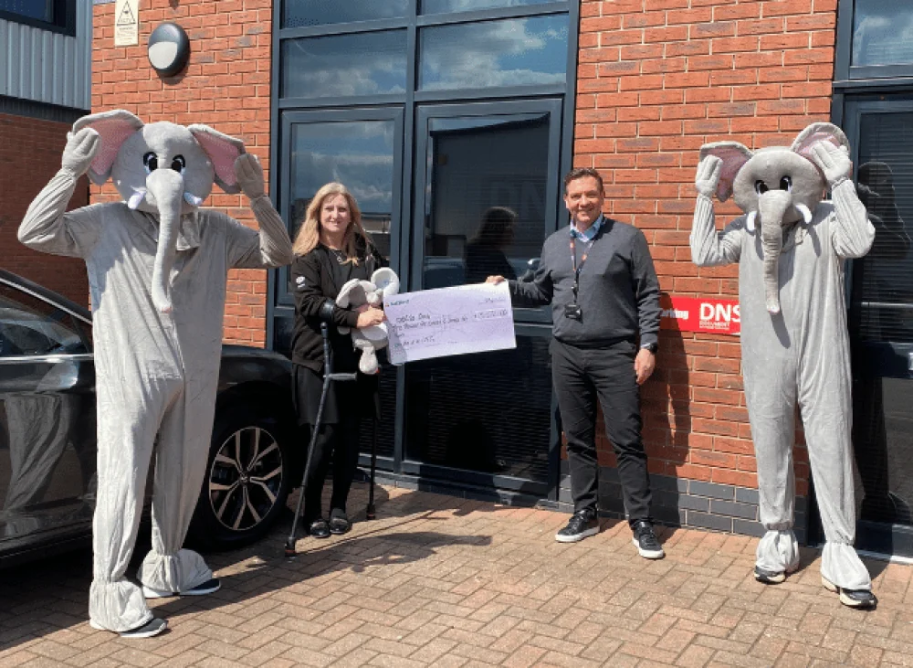 Darren presenting a cheque to Maria at me&dee charity in Derby
